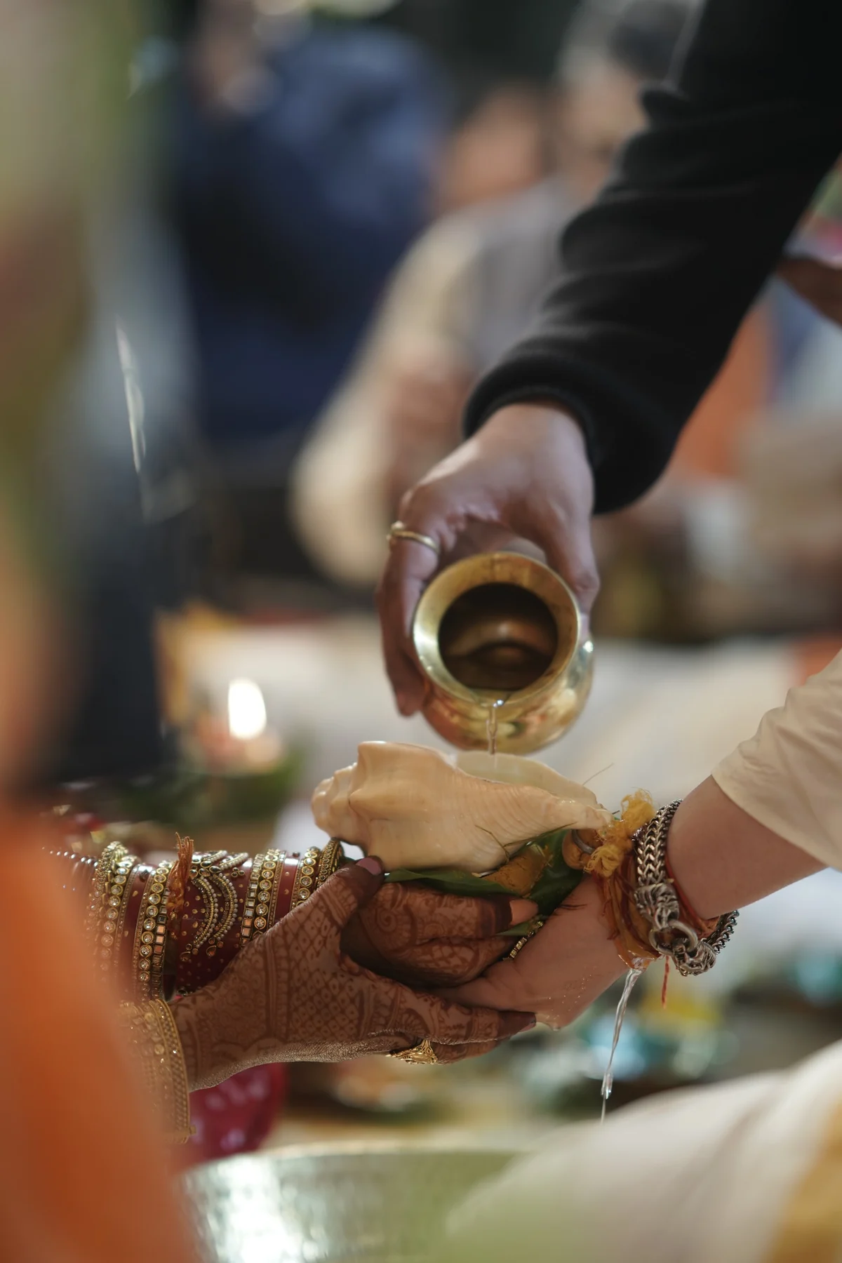 Close-up of Couple Hands Pouring Sacred Water